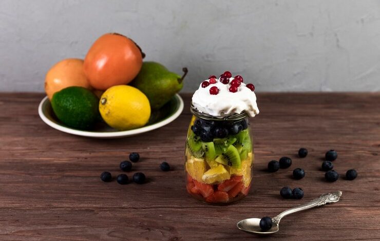 Ensalada de fruta fresca en mesa de madera con helado