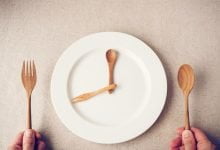 plato blanco con cuchara y tenedor, concepto de ayuno intermitente